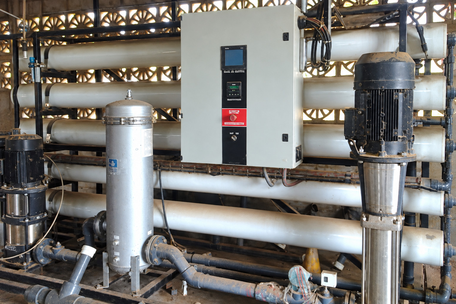 Equipo industrial de ósmosis inversa con membranas y panel de control. Imagen regenerada de referencia.